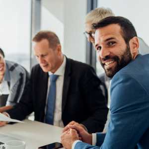 Image of men around a table smiling