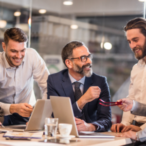 Group of people around laptops smiling